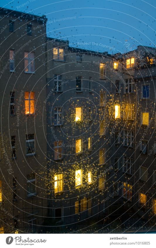 Regen am Abend dunkel Fenster Haus Herbst hinterhaus Regenwasser Häusliches Leben Wohnhaus Wohngebiet Mehrfamilienhaus Vorderseite Fensterfront erleuchten Licht