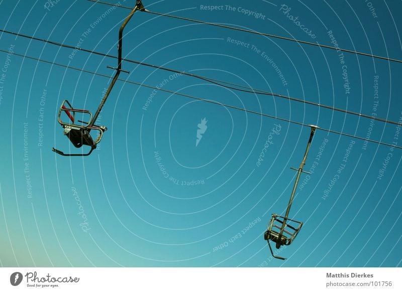 SESSELLIFT Sesselbahn Stahl grün alpin blau Neigung Steigung Skilift-Sitz 2 paarweise Stahlkabel abwärts himmelwärts diagonal Vor hellem Hintergrund Freisteller