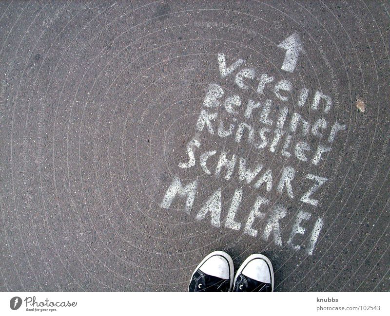 Schwarzmaler Beton Schuhe Schablone weiß grau Text spontan Richtung Club Verbote Verkehrswege Buchstaben Schriftzeichen Kunst Kultur Pfeil Graffiti Fund Verein