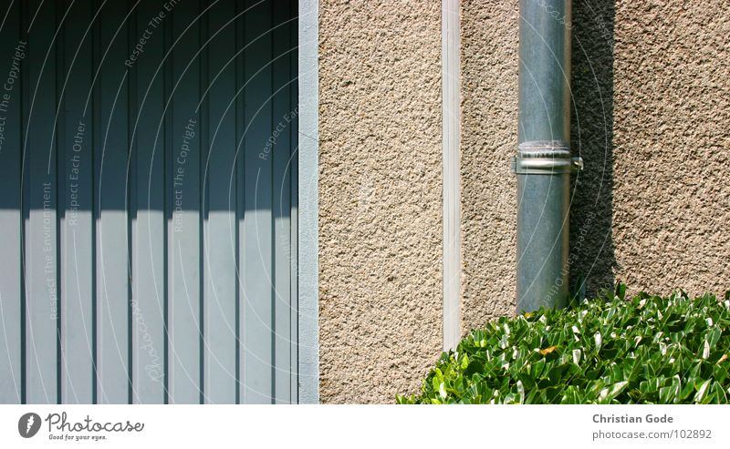 Garage, Mauer, Rohr und Busch Garagentor Einfahrt Gärtner Sträucher Fallrohr Schatten blau grün rot KFZ Einfamilienhaus Häusliches Leben Vorgarten Reihenhaus