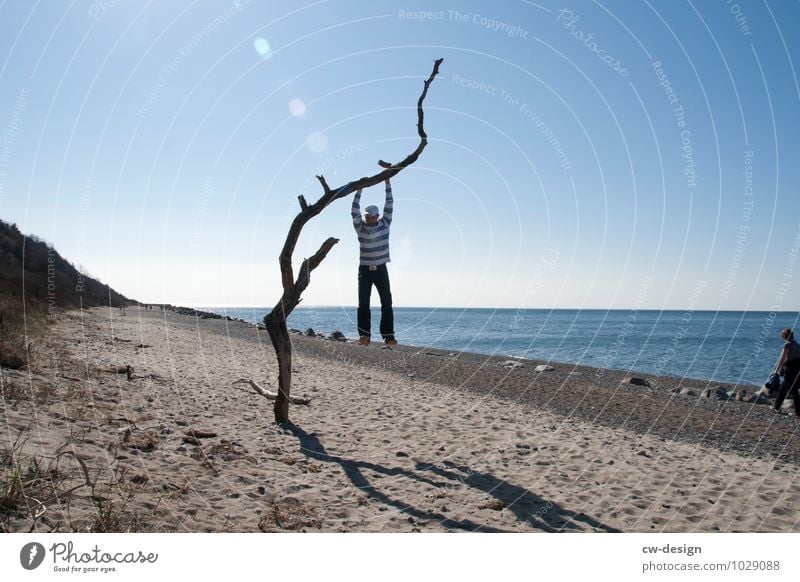 Jugendlicher am Baum hängend am Strand von Hiddensee blau Sandstrand