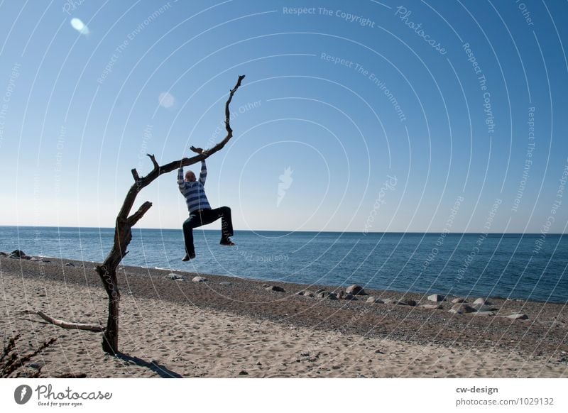 Jugendlicher am Baum hängend am Strand von Hiddensee Person blau Strandsand