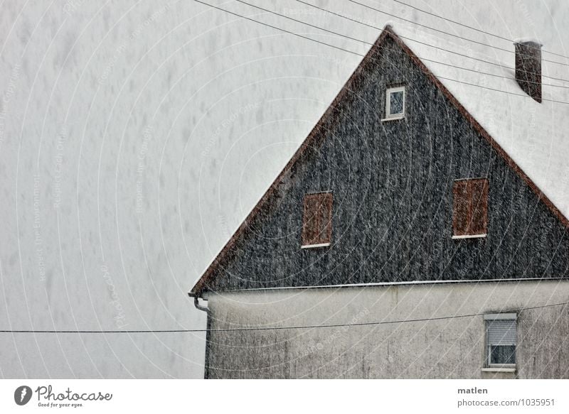 Schafskälte Dorf Menschenleer Haus Mauer Wand Fassade Fenster Dach Schornstein dunkel braun grau weiß Schneefall Telefonleitung Rollladen Architektur Farbfoto