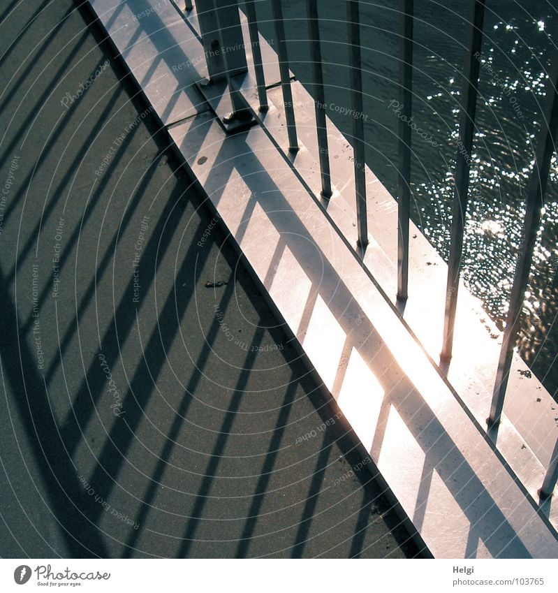 Licht und Schatten glänzend Geometrie dünn Ecke Sonnenlicht Gegenlicht Brücke Sommer Fluss Bach Geländer Stab Metall kahl Wasser Linie hoch verrückt Reflektion