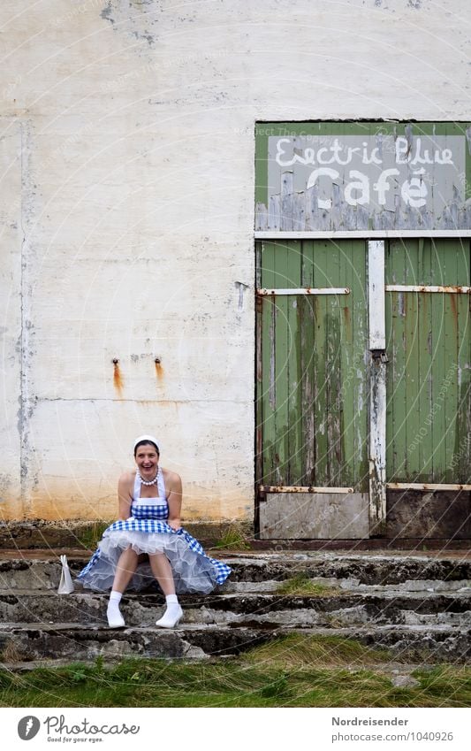 Lachende Junge Frau im Dirndl vor einer geschlossenen Location Lifestyle Stil Nachtleben Bar Cocktailbar ausgehen Feste & Feiern Tanzen Mensch feminin