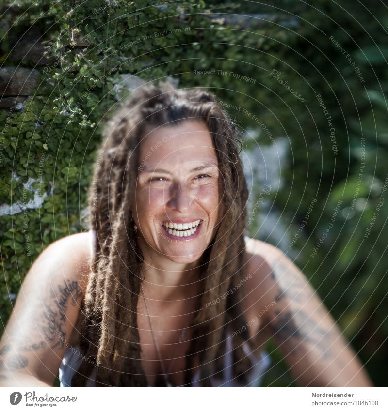 Junge Frau mit Dreadlocks lacht in die Kamera Lifestyle Leben Mensch feminin Jugendliche Erwachsene 1 30-45 Jahre Garten T-Shirt Accessoire Tattoo