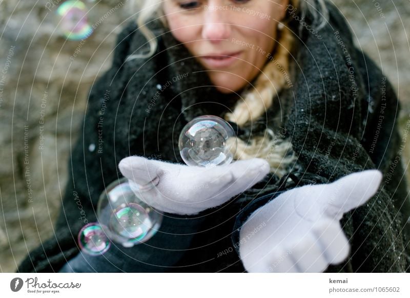 Frau mit Seifenblasen auf der Hand im Winter Freude Spielen Mensch feminin Erwachsene Leben 1 Stoff Decke Umhang Handschuhe blond langhaarig Zopf festhalten