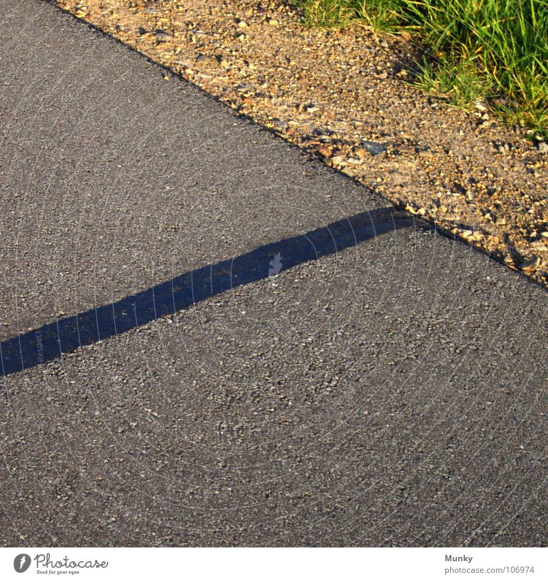 Wundversorgung Straße Straßenrand Kieselsteine grau schwarz Quadrat braun grün Pflanze Gras Gummi Teer Asphalt diagonal steigend aufsteigen Material Oberfläche