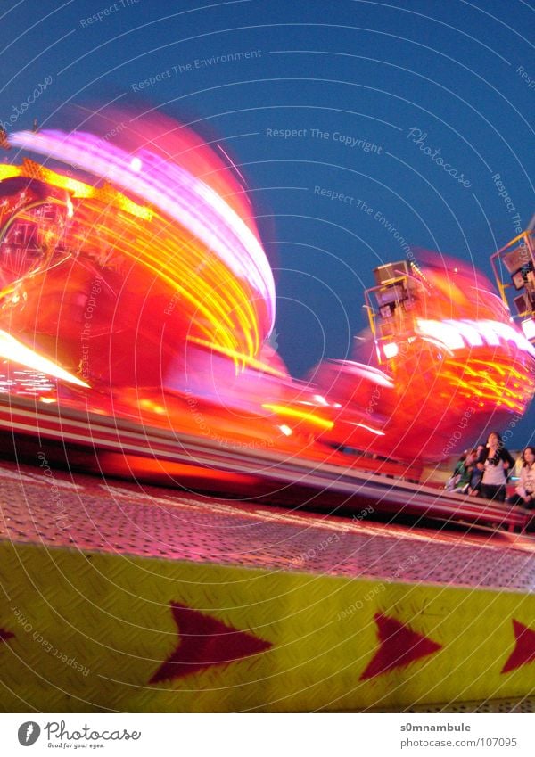 Rummel bei Nacht drehen Geschwindigkeit rot gelb Euphorie Jahrmarkt Licht Fahrgeschäfte Richtung Schwindelgefühl Langzeitbelichtung Freude Oktoberfest