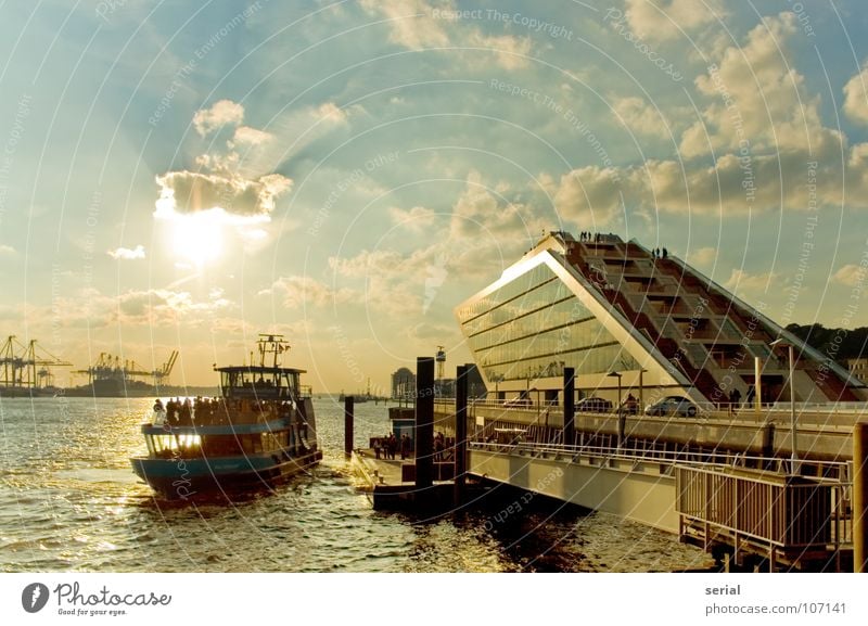 Schiff-Anleger-Haus Physik Gegenlicht Wasserfahrzeug Anlegestelle Fähre Kran Wolken Stahl Hafen Schifffahrt Sommer Himmel blau orange hell Wärme Sonne