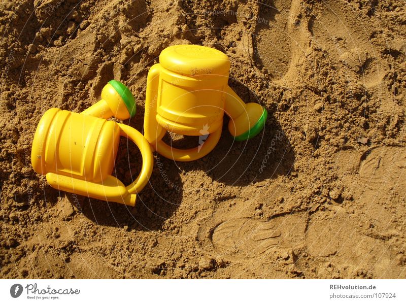 Sandkastenbefeuchtungszwillinge Zwilling identisch Spielen gelb grün Fußspur braun erdig Sommer 2 toben Freude liegen liegen gelassen gleich Gieskanne