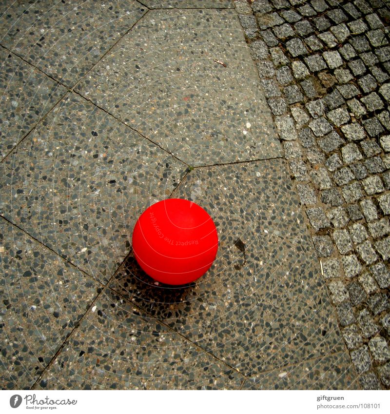 liegengeblieben Luftballon rot grau rund Verkehrswege Farbe fliegen Straße Kopfsteinpflaster Stein Ball