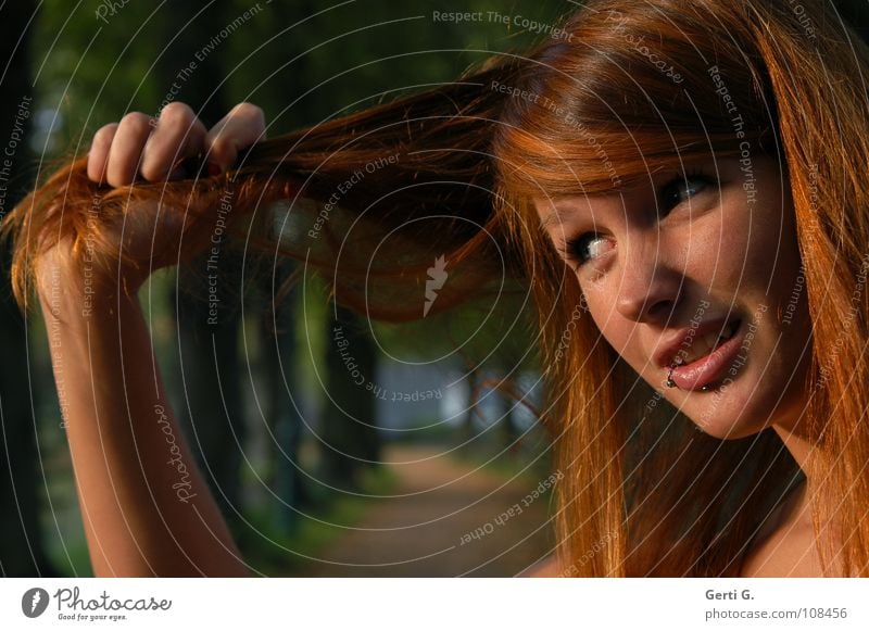 an den Haaren herbeigezogen Sprichwort Hand Unterarm Frau Junge Frau rothaarig langhaarig Piercing henna-rot Haarfarbe Sonnenlicht Rotstich Allee Baum Baumreihe