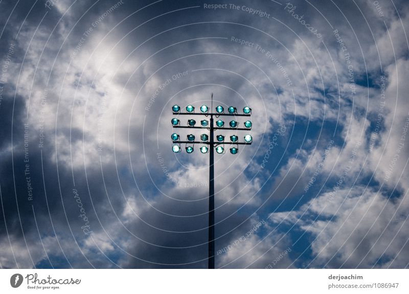 Im Schwimmbad gehen die Halogenlichter am Mast an. Im Hintergrund ganz viele dunkle Wolken. Freude ruhig Schwimmsport Sommer Wassersport Schwimmen & Baden