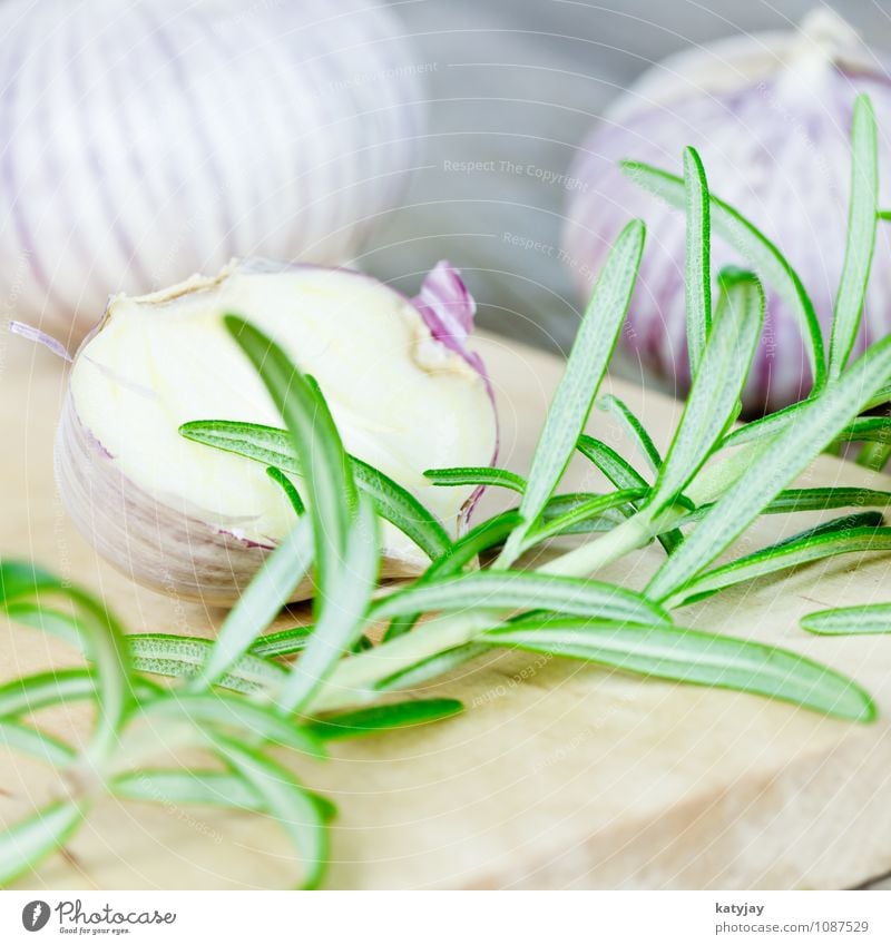 Knoblauch und Rosmarin Knoblauchzehe aromatisch Küchenkräuter frisch Kräuter & Gewürze Pfeffer nah violett Zehen Zutaten Holz Tisch Holzbrett Schneidebrett