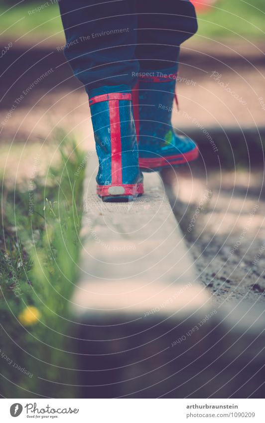 Kind in bunten Gummistiefel balanciert auf Sandkastenrand Freude Glück Spielen Kinderspiel Sommer Sonne Garten Mensch maskulin Kindheit Fuß 1 3-8 Jahre Natur