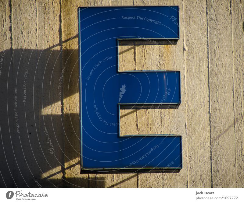 E wie Typographie Wand Beton Kunststoff blau authentisch Detailaufnahme Hintergrund neutral Silhouette Lichterscheinung Leuchtkasten hängen eckig Schattenspiel