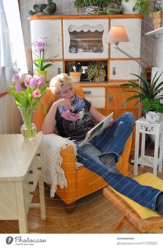 Frau zu Hause Büffet Brunch Haare & Frisuren Leben Freizeit & Hobby lesen Sonne Häusliches Leben Wohnung Möbel Sessel Tisch Küche Feierabend Erwachsene Zeitung