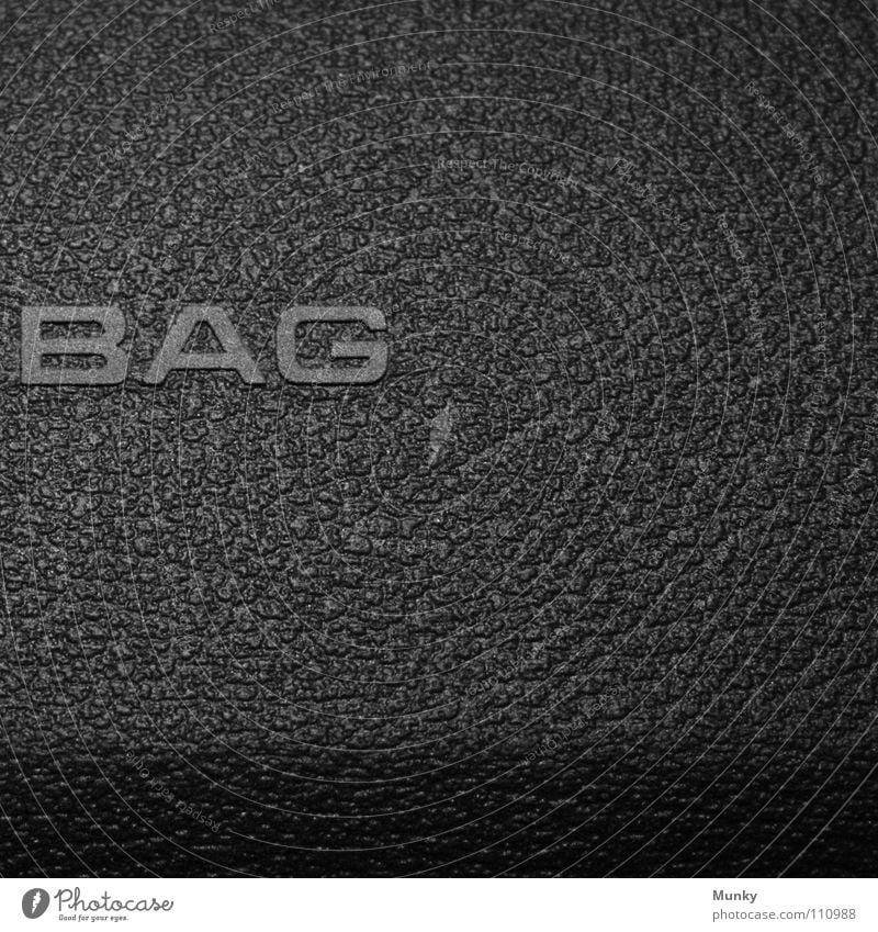 BAG Luft Airbag grau schwarz Aufschrift Buchstaben Sicherheit Quadrat zweiteilig 2 Makroaufnahme Nahaufnahme Munky PKW Amaturenbrett secure Schatten