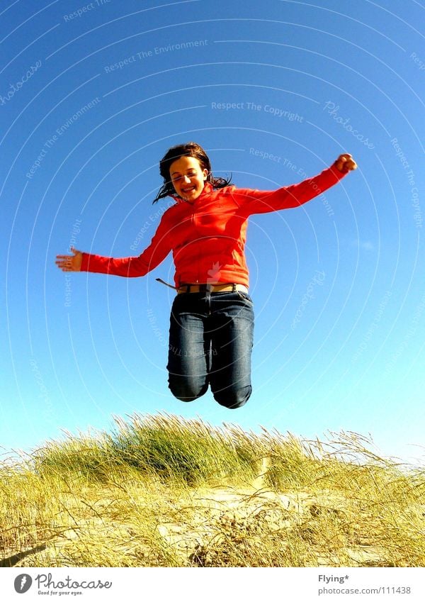 beine weg springen luftig Luft Gras Dünengras Ferien & Urlaub & Reisen Meer Strand fliegend Freude Sommer Erde Sand Himmel fallen Luftverkehr rote jacke