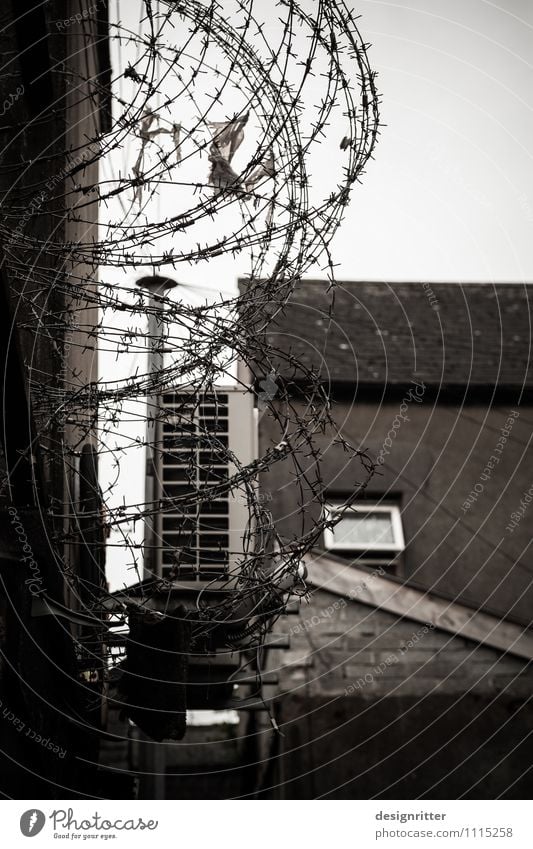 Alltäglicher Ausnahmezustand Stadt Haus Mauer Wand Fenster Dach Hof Hinterhof Zaun Stacheldraht Stacheldrahtzaun dunkel Angst Verzweiflung Rache Gewalt Hass