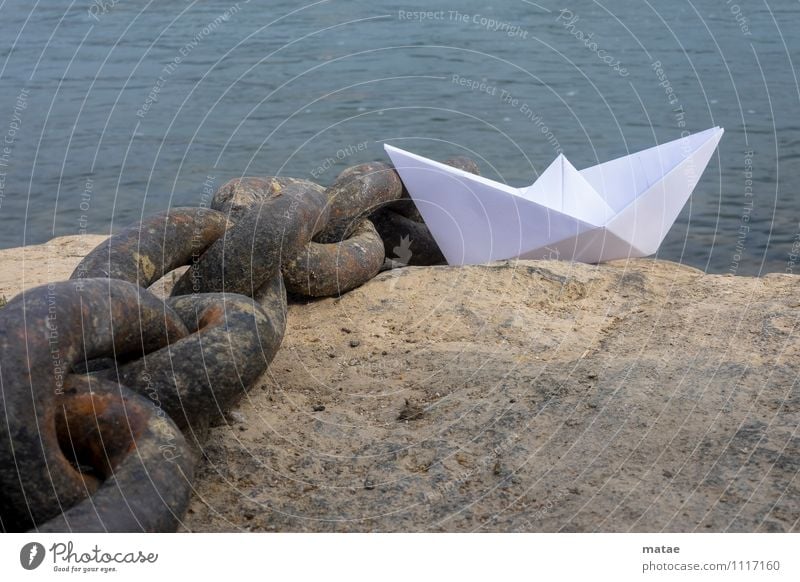 Papierschiffchen an die Kette gelegt Wasser Segelschiff blau Sehnsucht Fernweh Verzweiflung Freiheit Boot Wasserfahrzeug Felsen Dock Trosse Ufer Reiselust