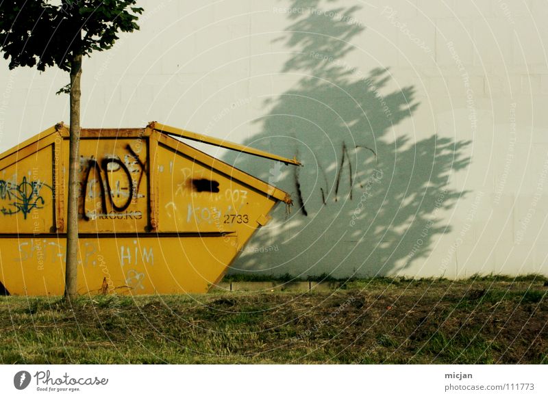 M wie Müll Müllbehälter gelb Baum Wiese Wand grau Pastellton Müllabfuhr Papiercontainer Schatten Sommer oben Klappe Recycling Müllverwertung Umweltschutz