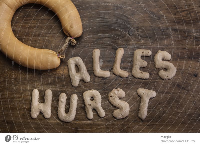 Die Buchstaben ALLES WURST auf einem rustikalen Holzbrett mit einer Wurst Wurstwaren Kochwurst Übergewicht Essen dick verrückt braun gefräßig Hemmungslosigkeit