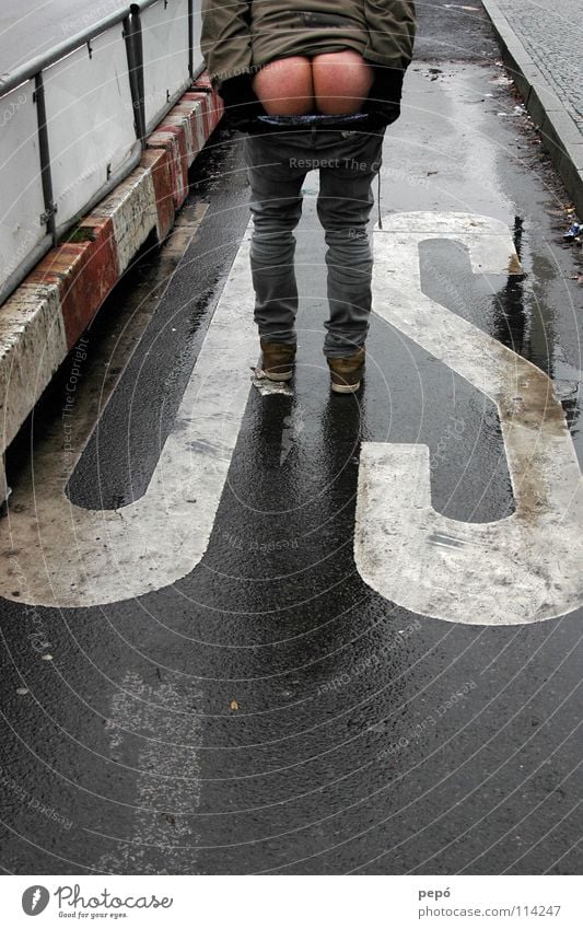 *u.ass.a.* Mann nackt protestieren Aufstand Zaun Ass Handschuhe nass Bordsteinkante Hosen runter Amerika Wut Ärger Hinterteil Straße Jeanshose Wiedervereinigung