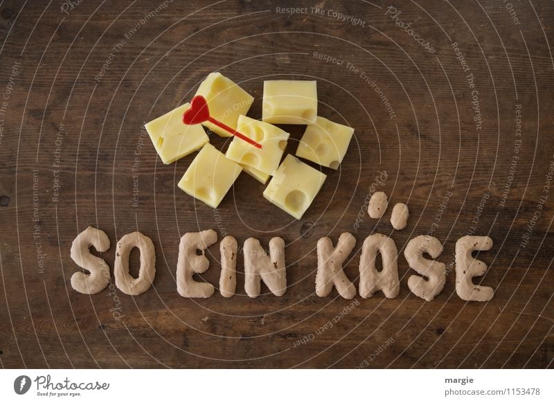 Die Buchstaben  SO EIN KÄSE auf einem rustikalen Holztisch mit Käsewürfel und Herz -Pieker Lebensmittel Milcherzeugnisse Ernährung Frühstück Abendessen Picknick