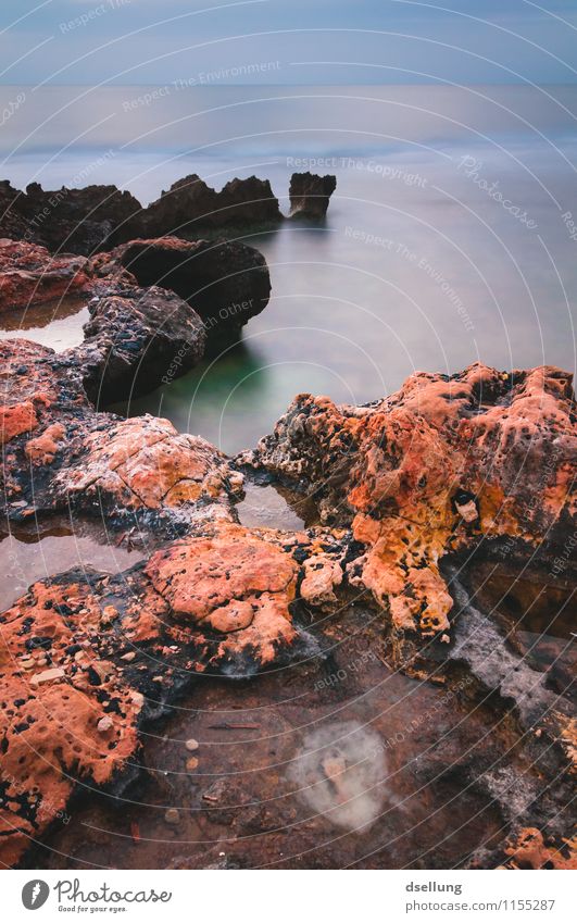 Orangefarbene Felsen im Meer Außenaufnahme Farbfoto ruhig Erholung Küste Wellen Landschaft Natur Ferne Ausflug Ferien & Urlaub & Reisen orange Mittelmeer Licht