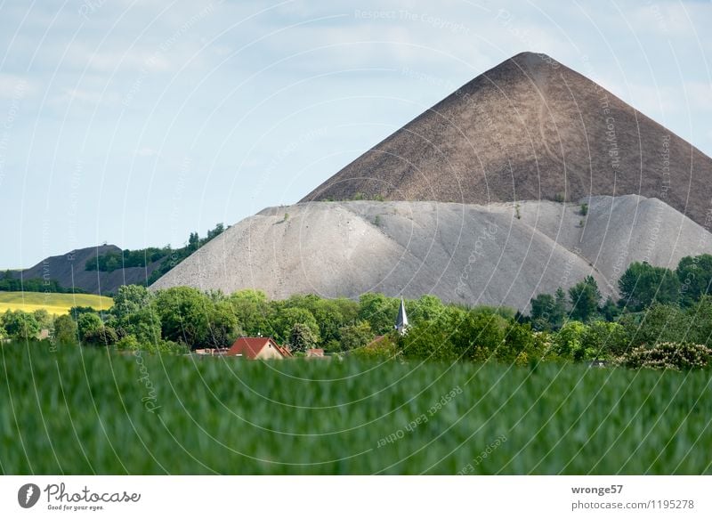 Häuser und Kirche von Volkstedt vor den Abraumhalden des Bergbaus im Mansfelder Revier Halde Sachsen-Anhalt Deutschland Europa Dorf Haus Dach Kirchturm