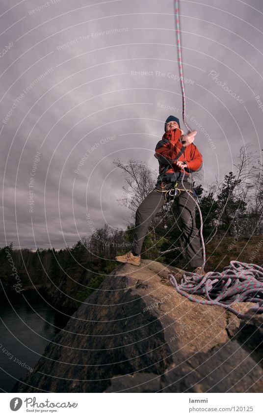 am Berg Bergsteigen Sturm Wolken kalt Einsamkeit Abenteuer maskulin Sport Spielen Felsen Klettern Seil Sicherheit werfen Held Freiheit Außenaufnahme