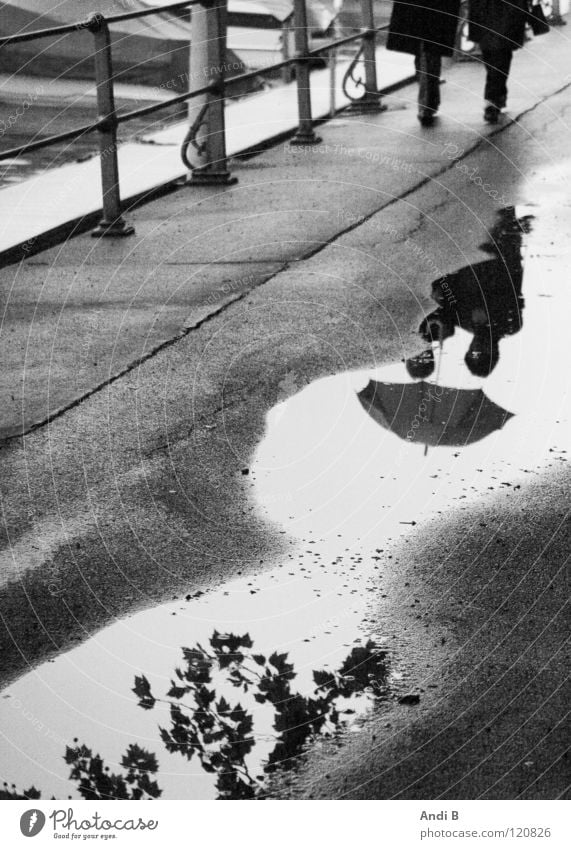 Spazieren im Regen Spaziergang Pfütze Frau Reflexion & Spiegelung zwei Menschen Schwarzweißfoto Reflexionen im Wasser Traurigkeit