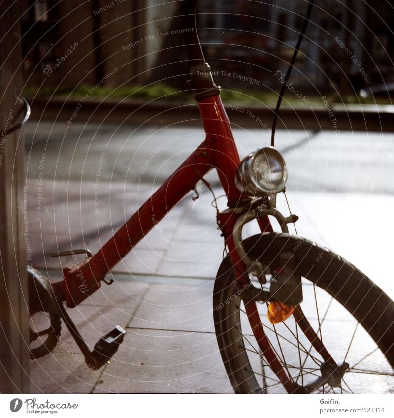 St. Pauli Nebenstraßen I Reeperbahn Tag Schönes Wetter Fahrrad Lampe Klapprad Rost entdecken angekettet Seitenstraße Blick rot Pedal Straßenrand Verkehrswege