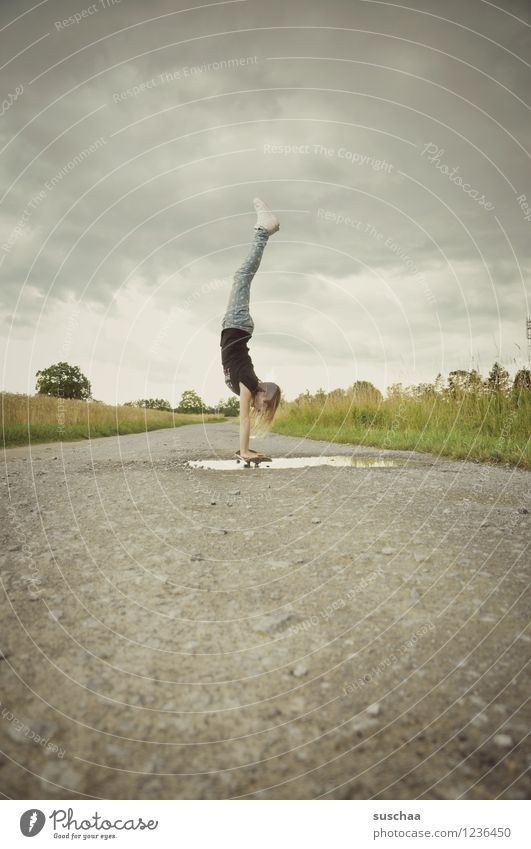 der handstand . Wege & Pfade Asphalt Außenaufnahme Pfütze Kind Mädchen Skateboarding Handstand Wolken Himmel Kindheit sportlich Kindererziehung Freiheit