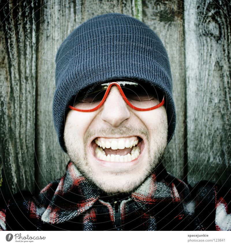 Rock it! (3) Mann Porträt Freak erschrecken Wand Holz Brille Sonnenbrille Mütze Winter kalt frieren Achtziger Jahre lässig skurril Humor Freude Zunge