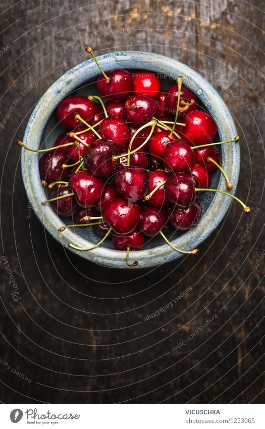 Süße Kirschen in blauer Schüssel auf dunklem Holztisch Lebensmittel Frucht Ernährung Frühstück Bioprodukte Vegetarische Ernährung Diät Schalen & Schüsseln Stil