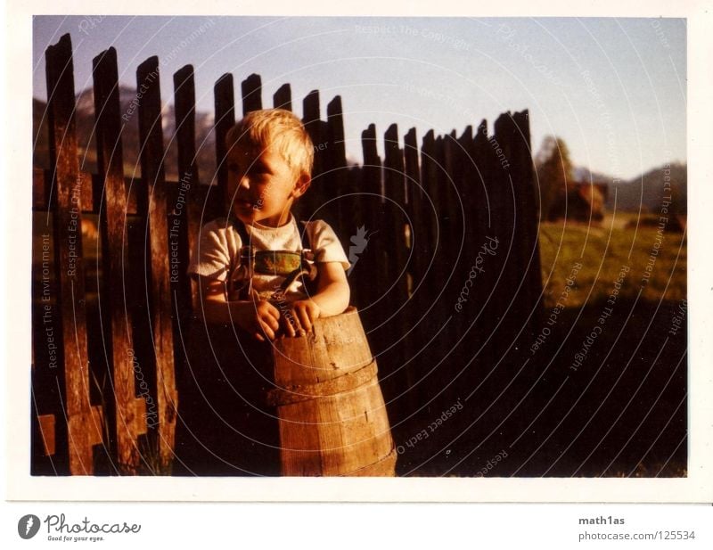 old-skool 1 Junge old-school Fass Zaun Wiese Holz Hemd Tracht Waldmensch blond Fence Himmel DDR 90 80 70 60 Krachlederne Bauernsohn Natur Landwirtschaft