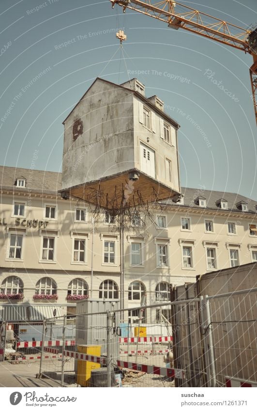 umzug mit haus gebäude kran stadt baustelle bauzaun absperrung stadtleben aufhängen