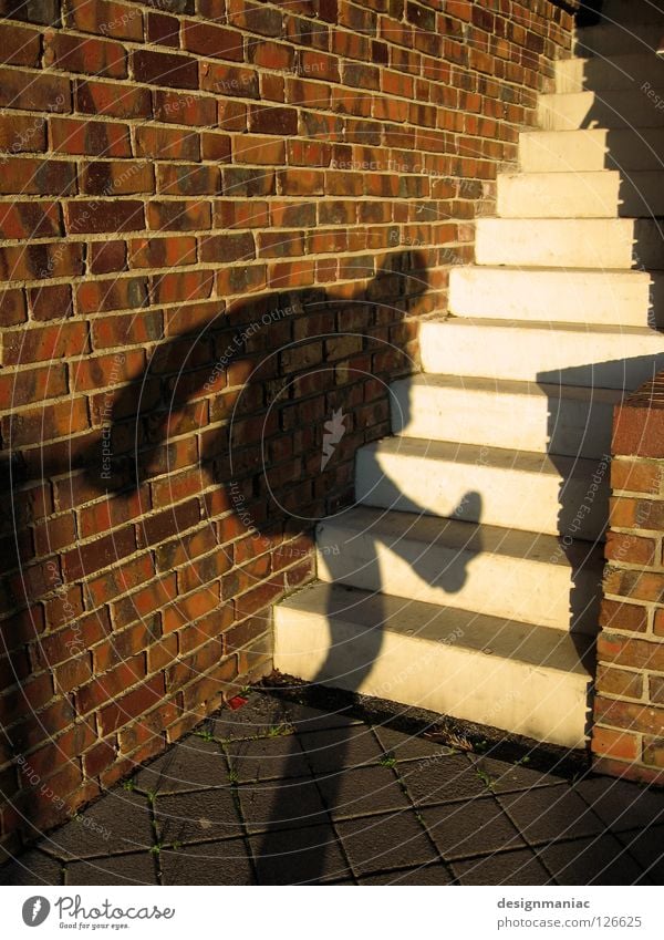 Schattendasein Wand Dieb Backstein Licht schwarz rot weiß Mauer Schlagschatten steigen Eingang Besucher Treppe Sonne aufwärts Beine oben hoch Stein