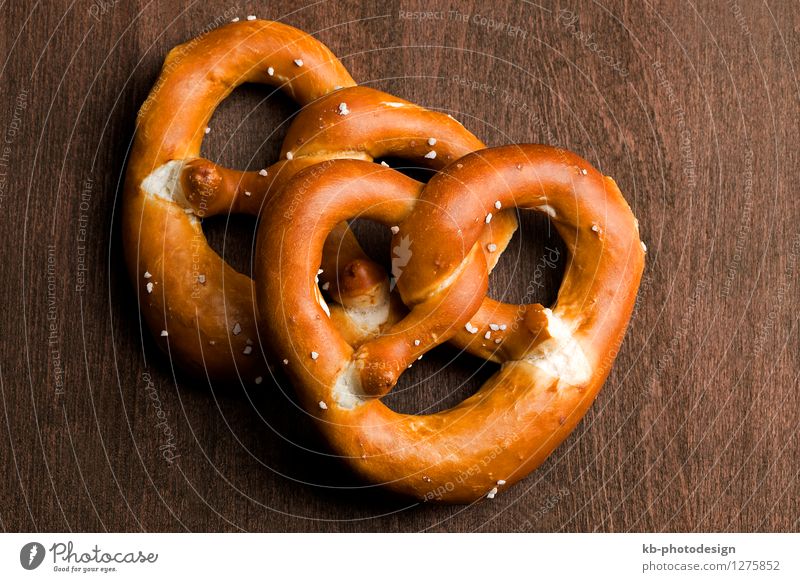 Bavarian pretzel on a brown background Lebensmittel Teigwaren Backwaren Ernährung Essen Oktoberfest München Deutschland Feste & Feiern eat cheers invitation