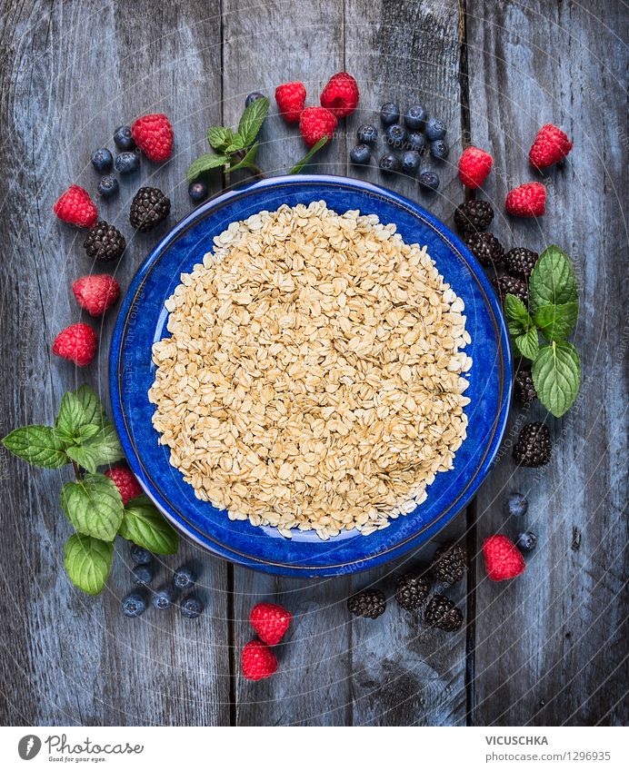 Haferflocken in blauer Schüssel mit Beeren Lebensmittel Frucht Getreide Ernährung Frühstück Bioprodukte Vegetarische Ernährung Diät Teller Schalen & Schüsseln