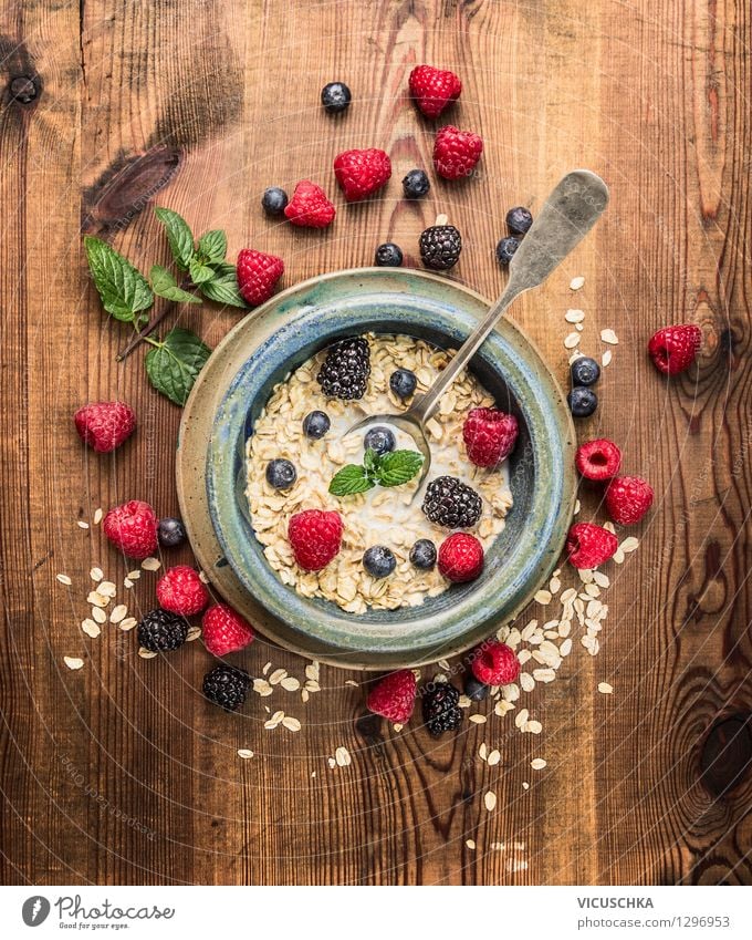 Haferflocken mit Milch und Beeren zum Frühstück Lebensmittel Milcherzeugnisse Frucht Getreide Ernährung Bioprodukte Diät Teller Schalen & Schüsseln Löffel Stil