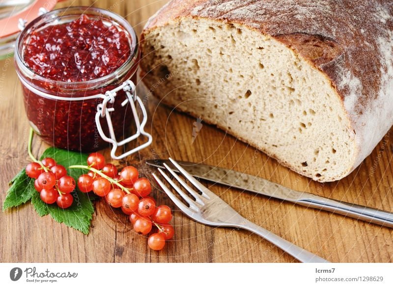 red currant jam and fresh bread Frucht Brot Marmelade Ernährung Frühstück Besteck Messer Gabel Essen currants breakfast fruit bowl blue white table wood