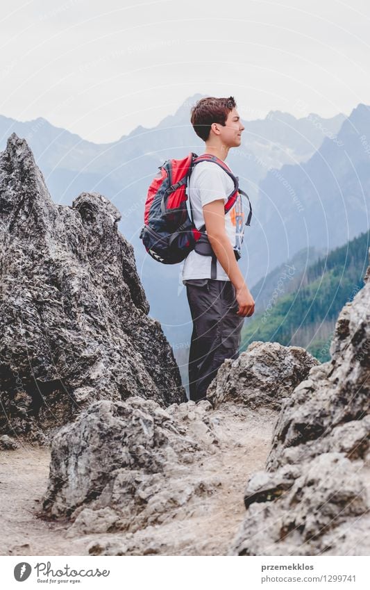 Junge, der auf den Felsen in den Bergen steht Ferien & Urlaub & Reisen Ausflug Abenteuer Sommer Sommerurlaub Berge u. Gebirge wandern Kind Junger Mann