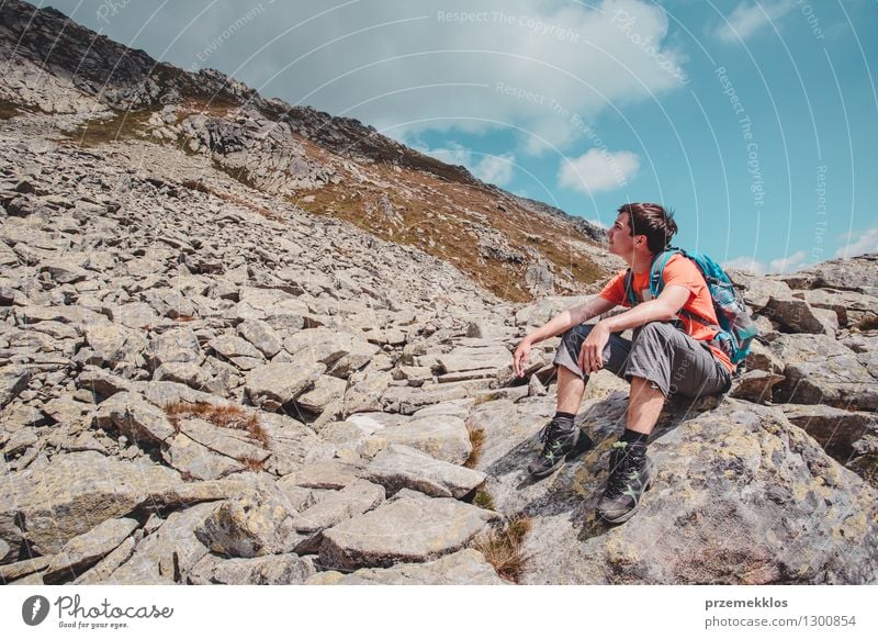 Junge, der auf einem Felsen in den Bergen stillsteht Lifestyle Ferien & Urlaub & Reisen Ausflug Abenteuer Freiheit Sommer Berge u. Gebirge wandern Junger Mann