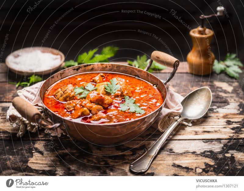 Gulasch im Kupfertopf mit Löffel auf rustikalem Küchentisch Lebensmittel Fleisch Gemüse Kräuter & Gewürze Ernährung Mittagessen Abendessen Topf Design Tisch