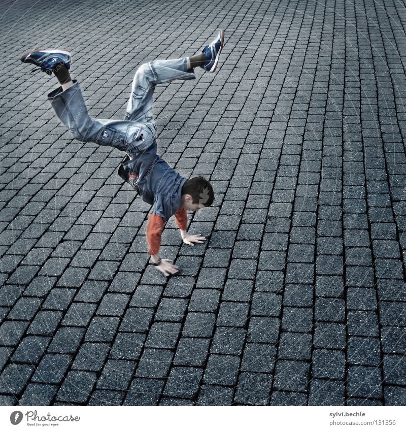 walking on hands Farbfoto mehrfarbig Außenaufnahme Textfreiraum rechts Textfreiraum unten Tag Starke Tiefenschärfe Ganzkörperaufnahme Blick nach unten Wegsehen