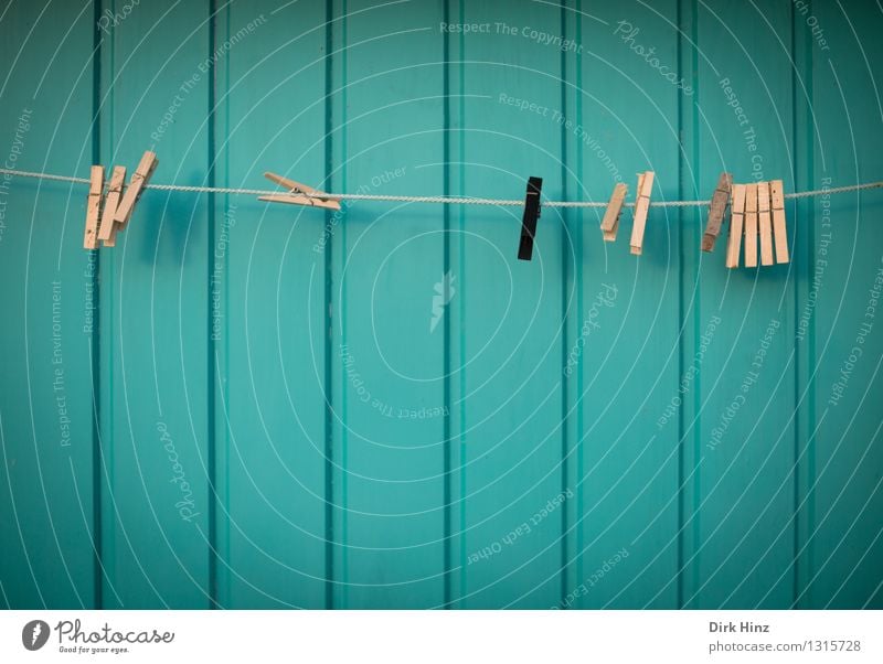 Allein in der Menge Häusliches Leben Wohnung Zeichen hängen außergewöhnlich braun schwarz türkis Klammer Wäscheklammern Wäscheleine Fassade Fassadenverkleidung